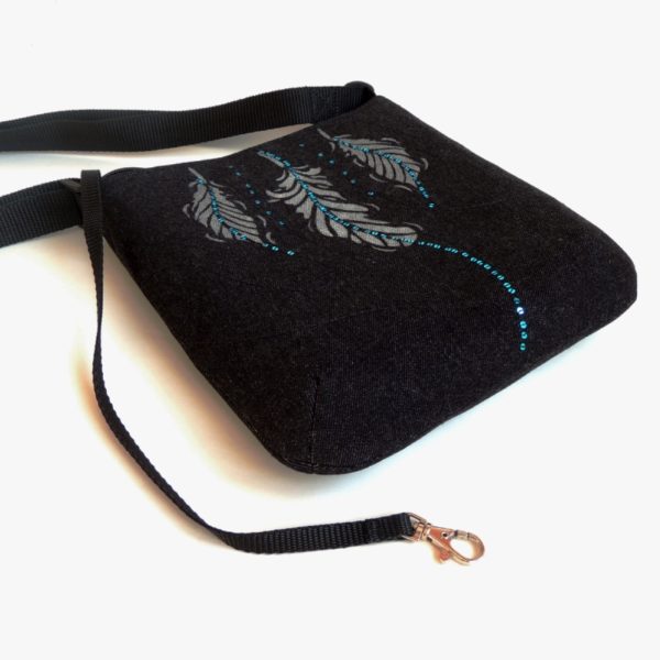 lehká textilní kabelka sportovního střihu z černého riflového materiálu s bílým ozdobným prošíváním s potiskem peříček a s flitry