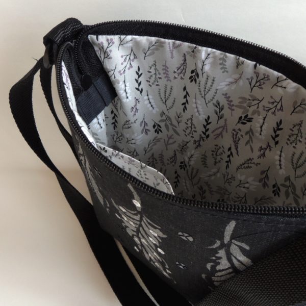 lehká textilní kabelka sportovního střihu z černého riflového materiálu s bílým ozdobným prošíváním s potiskem stříbrných peříček a s flitry