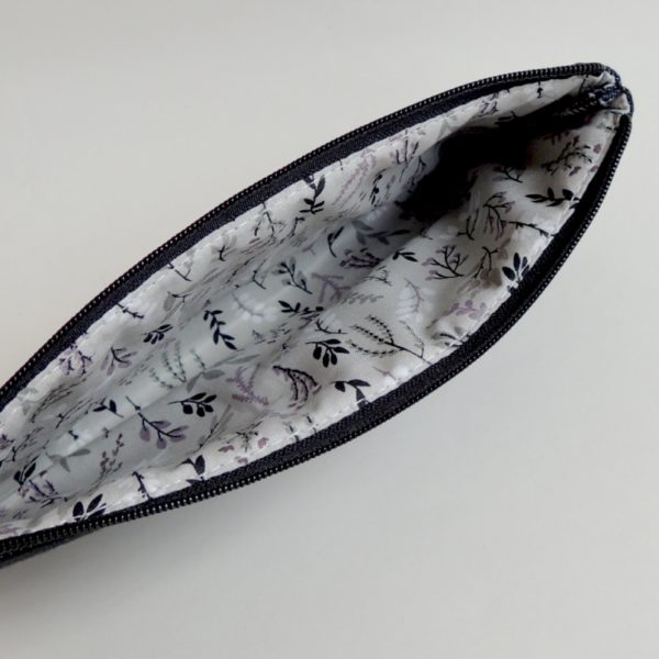 lehká textilní kabelka sportovního střihu z černého riflového materiálu s bílým ozdobným prošíváním s potiskem stříbrných peříček a s flitry