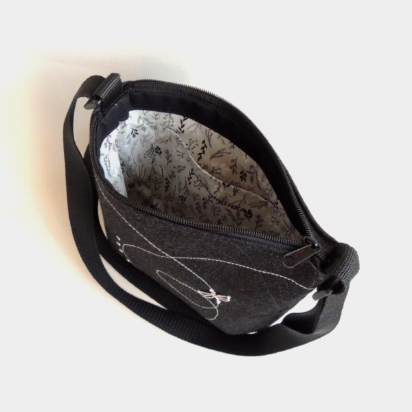 lehká textilní kabelka sportovního střihu z černého riflového materiálu s bílým ozdobným prošíváním a stříbrnou vážkou