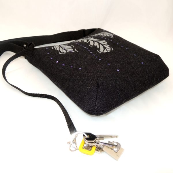 lehká textilní kabelka sportovního střihu z černého riflového materiálu s potiskem tří peříček a s flitry